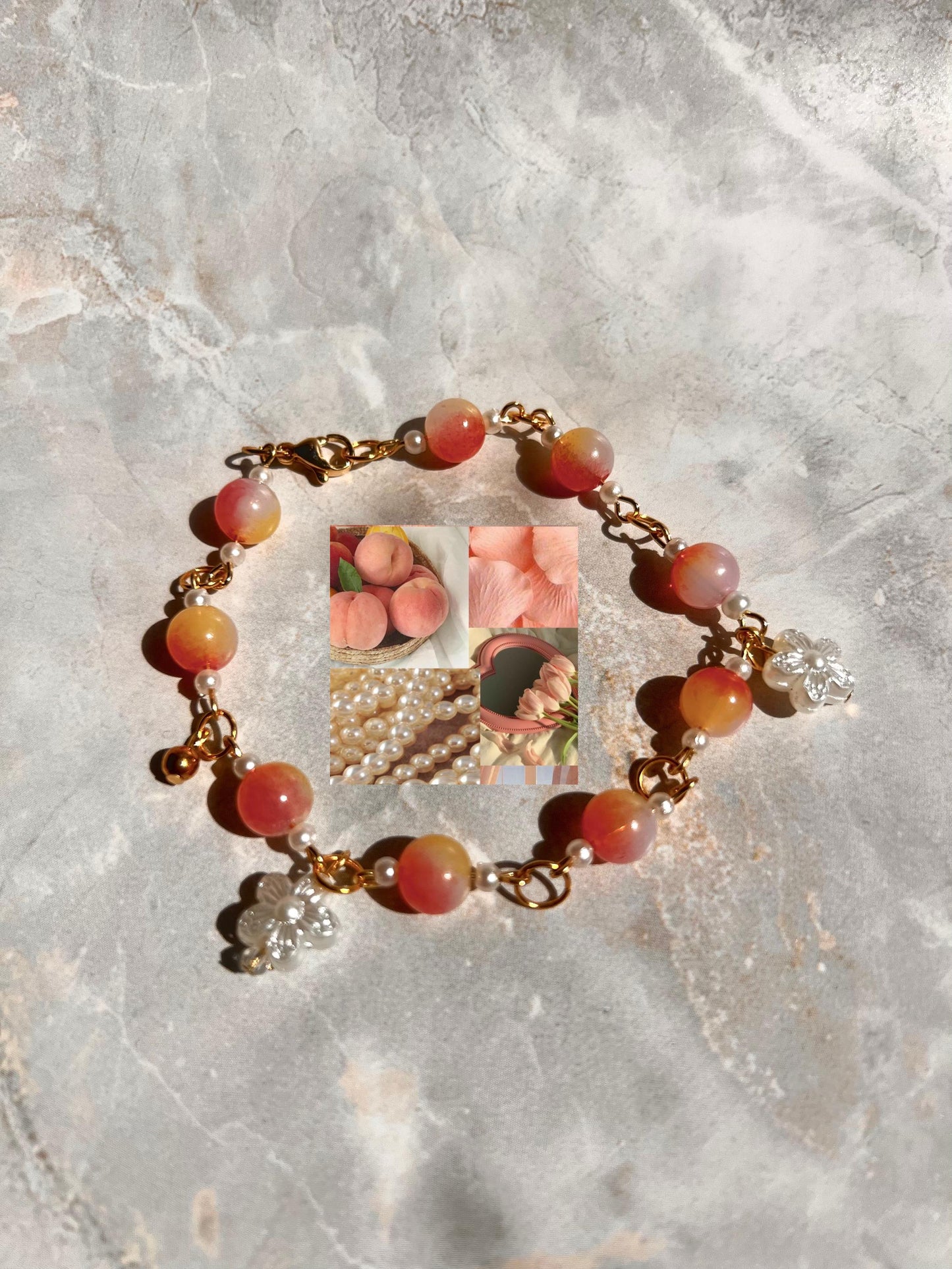 A peach-colored beaded bracelet with gold accents and small flower charms. The beads are a gradient of peach and white. The bracelet is on a gray textured surface.